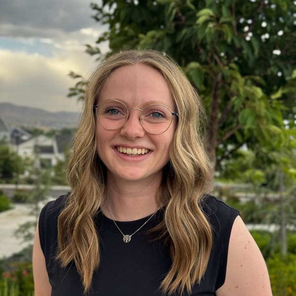Megan Jackman smiling outdoors in front of green trees